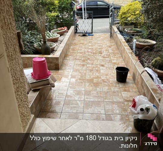 דלי שחור, מגב ורצפה רטובה בכניסה לבית